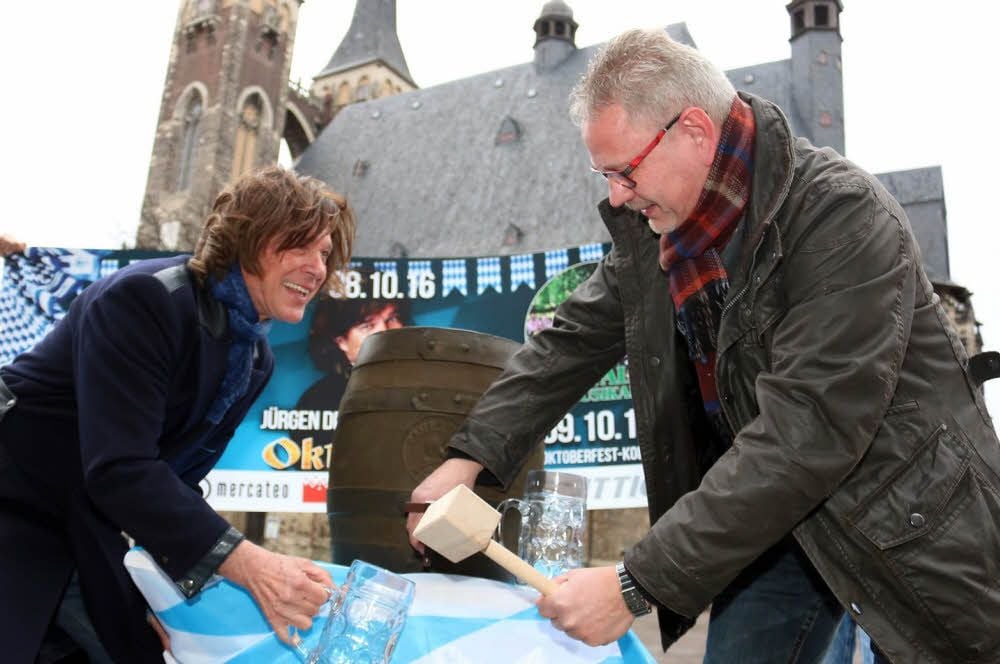 Jürgen Drews und Köthens noch nicht amtierender OB Bernd Hauschild probieren sich beim Fassanstich auf dem Markt.