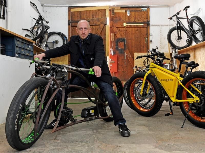 Christian Kelemen in seiner Fahrrad-Werkstatt im Fischereihafen von Bremerhaven (Bremen) auf seinem neuesten E-Bike-Chopper. Foto: Ingo Wagner