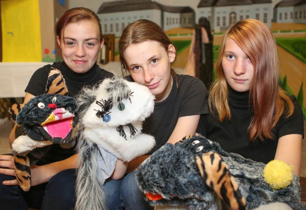 Die Schüler zeigen stolz ihre Puppen.