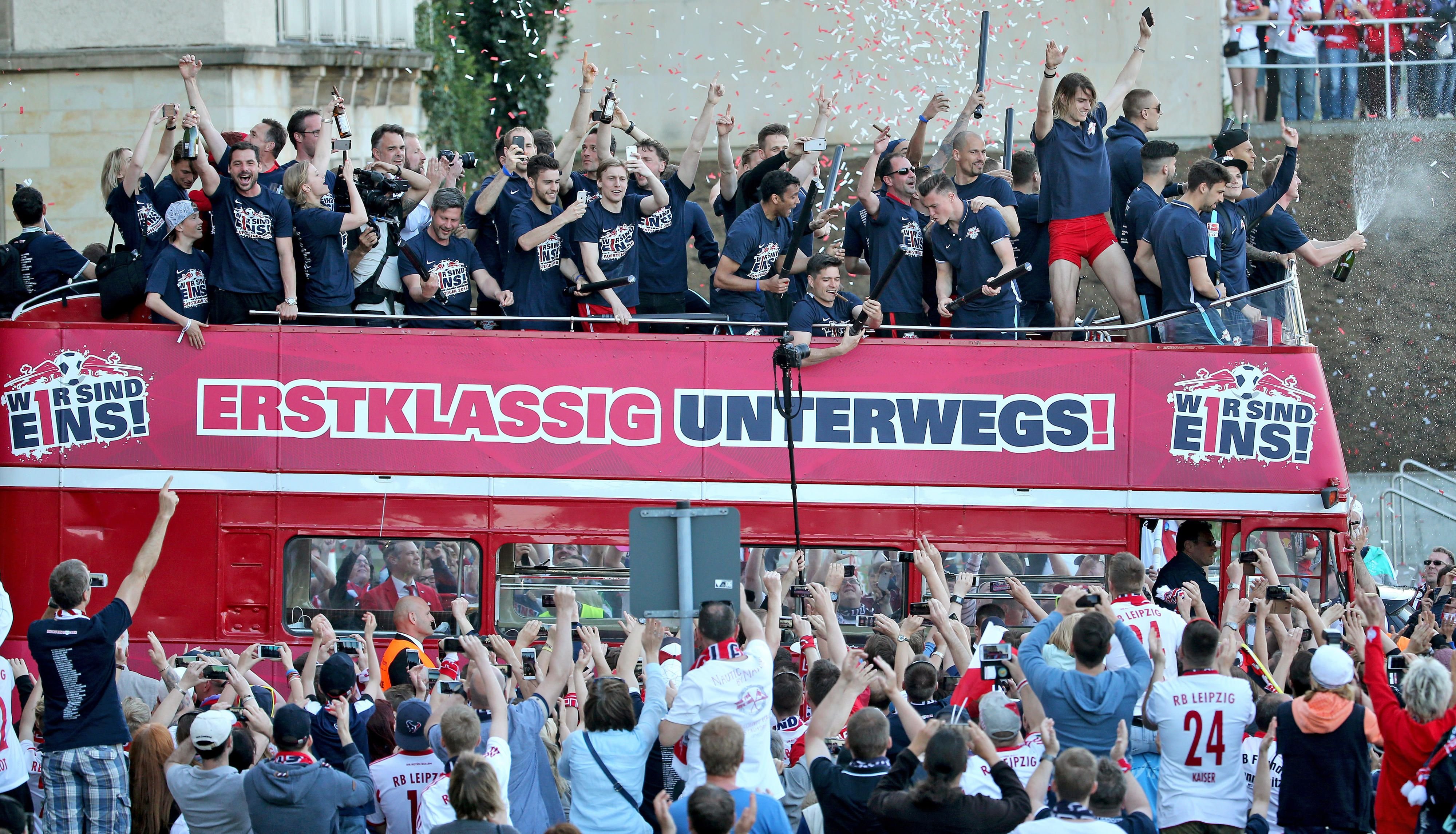 Die Leipziger Spieler jubeln von einem offenen Bus nach dem Aufstieg in die 1. Bundesliga.