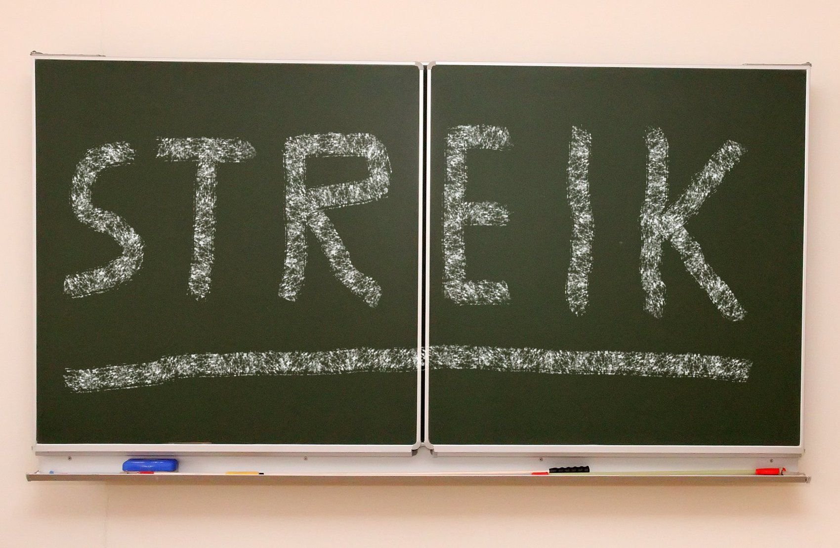 Das Wort "Streik" steht mit Kreide an einer Schultafel