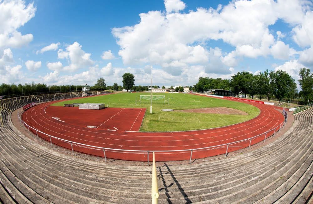 Das Stadtstadion, betrachtet aus der Sicht der Gäste-Fans. Rechts steht die überdachte Sitztribüne, links sind die Wechselbänke und der Sprecherturm.