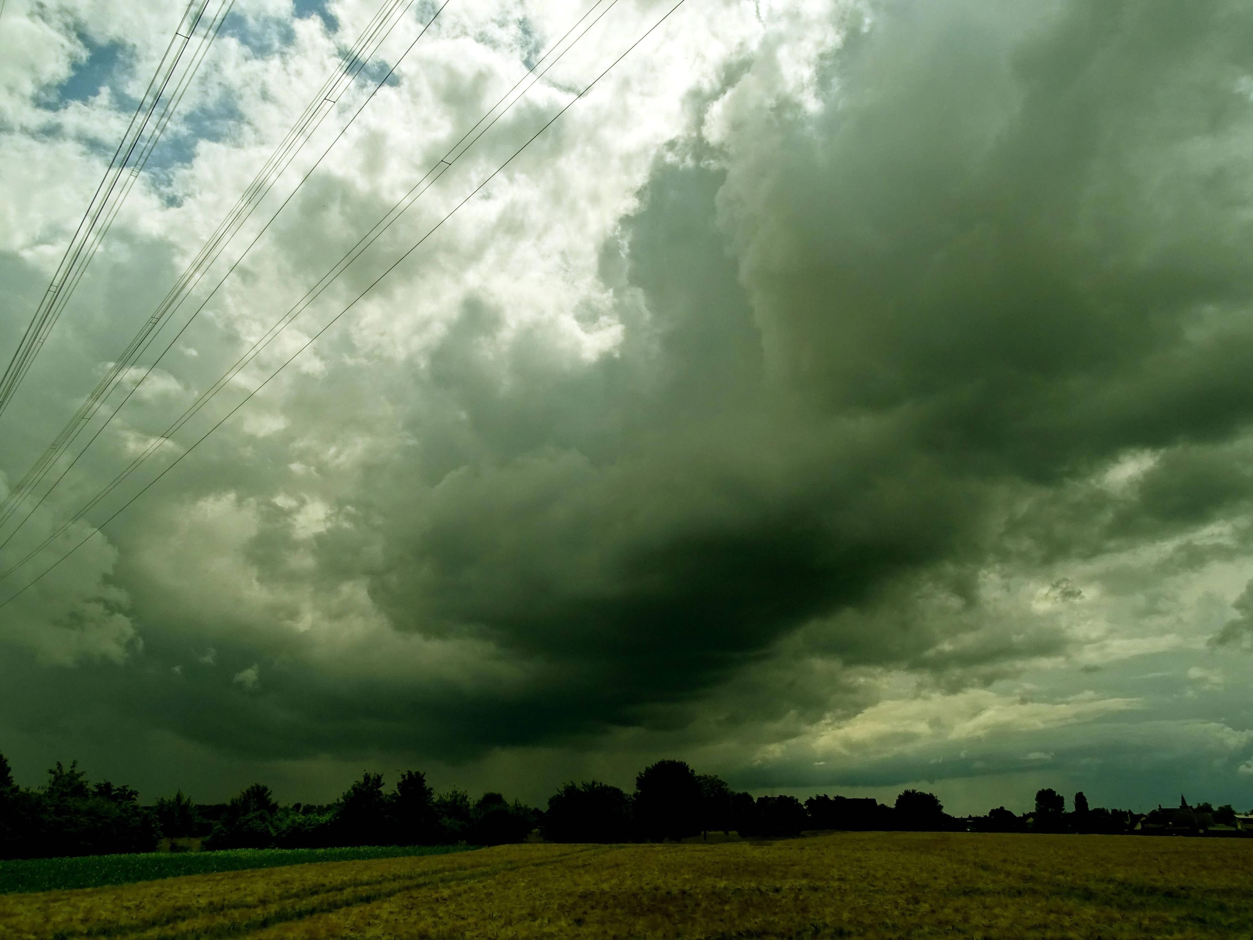 Ein Unwetter zieht über einem Feld auf.