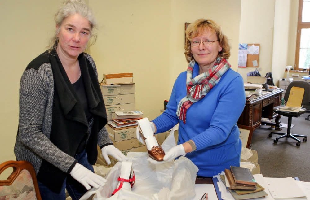 Andrea Müller (links) und Museumsmitarbeiterin Angela Sengewald sichten Exponate für die neue Schuhausstellung.