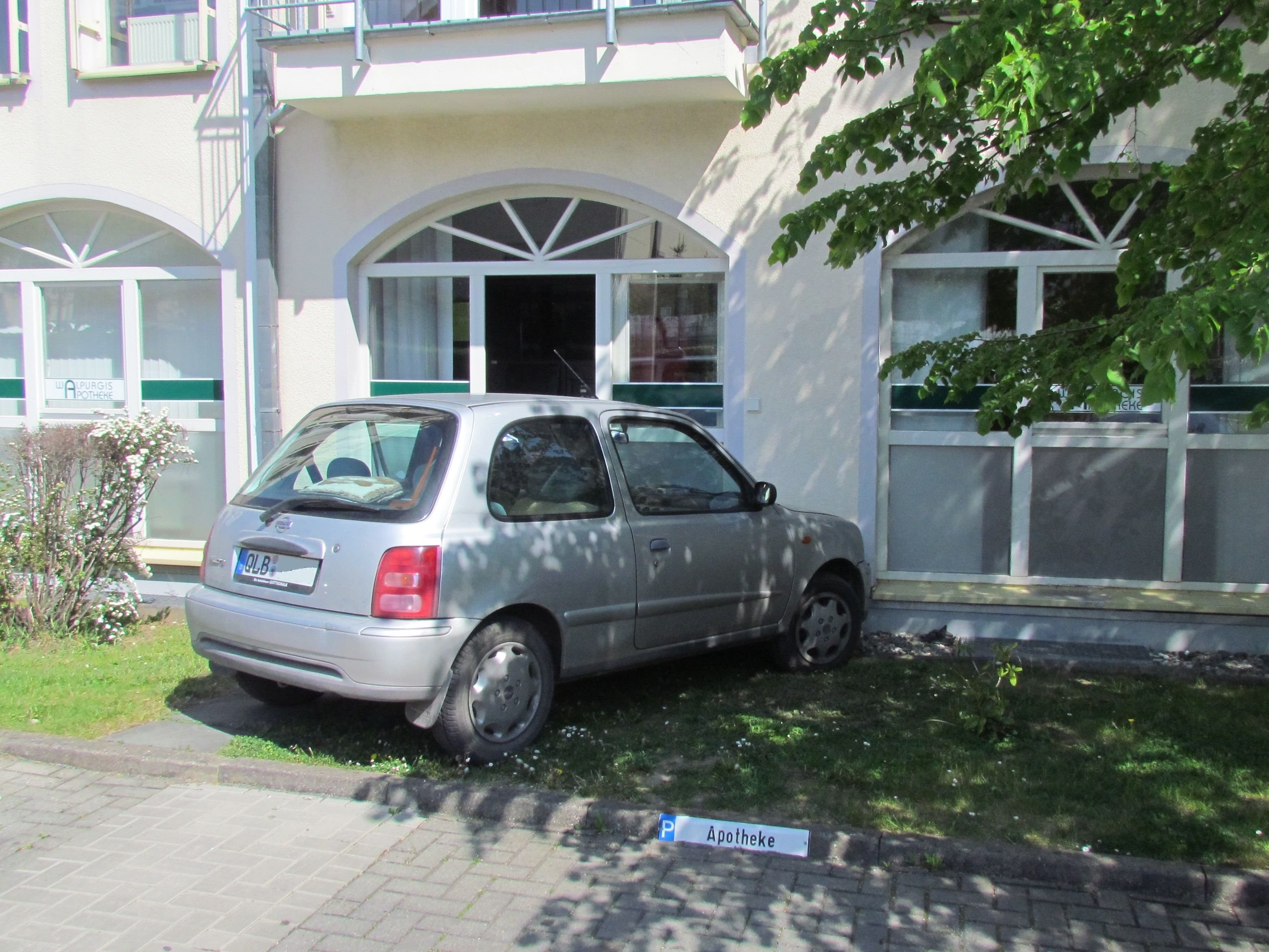 Der Nissan Micra steht nach dem Unfall an der Wand eines Wohn- und Geschäftshauses in der Heinrich-Heine-Straße in Thale.