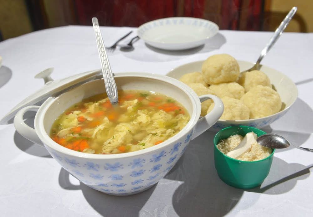Marion Henning ist von Beruf Köchin. Entsprechend routiniert geht sie in der Küche zu Werke - egal ob beim Einfüllen der Brühe, dem Zerkleinern von Petersilie oder dem Kneten des Kloßteiges. Angerichtet sieht die Brühe mit Klößen und frisch geriebenem Meerrettich mehr als lecker aus.