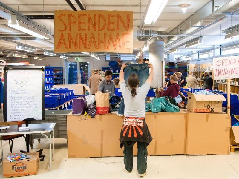 Helfer sortieren gespendete Kleidung. Foto: Daniel Bockwoldt