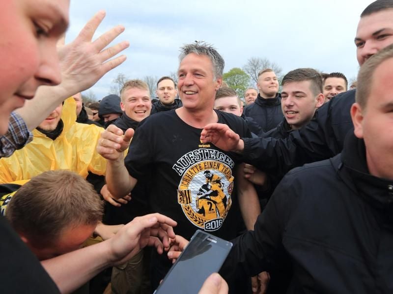 Uwe Neuhaus (M) ist der Vater des Erfolgs. Dresdens Trainer jubelt nach dem Aufstiegsspiel mit den Fans. Foto: Jens Wolf