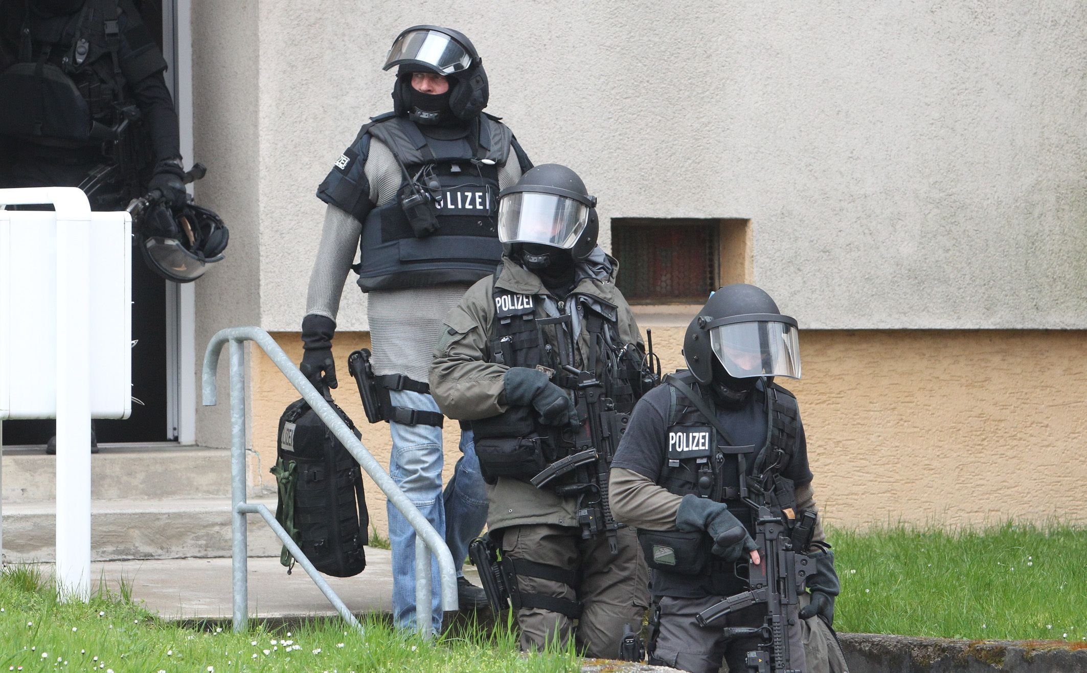 Spezialkräfte der Polizei verlassen in Schkeuditz nach dem Ende des Einsatzes das Haus des Täters.