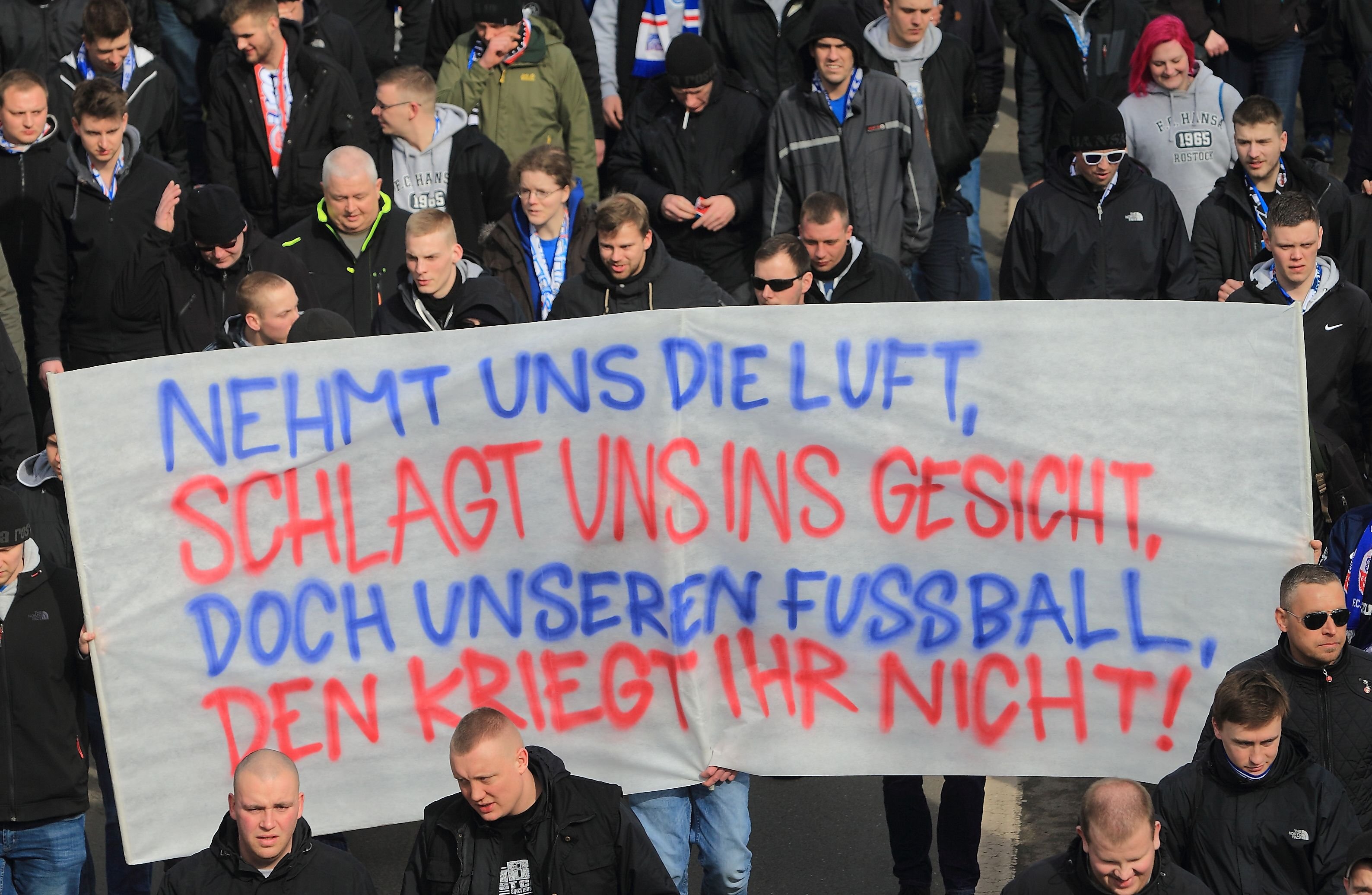 Anhänger von Hansa Rostock tragen beim Marsch in Richtung Stadion ein Transparent mit der Aufschrift "10% sonst Nixx" in Richtung Stadion.