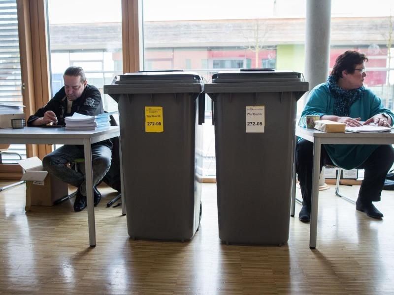 Ab in die Tonne: Zwei große, graue Mülltonnen als Wahlurnen in einem Frankfurter Wahllokal. Rund 4,7 Millionen Hessen und 360.000 nichtdeutsche EU-Staatsbürger sind zu den Kommunalwahlen in Hessen aufgerufen. Foto: Frank Rumpenhorst