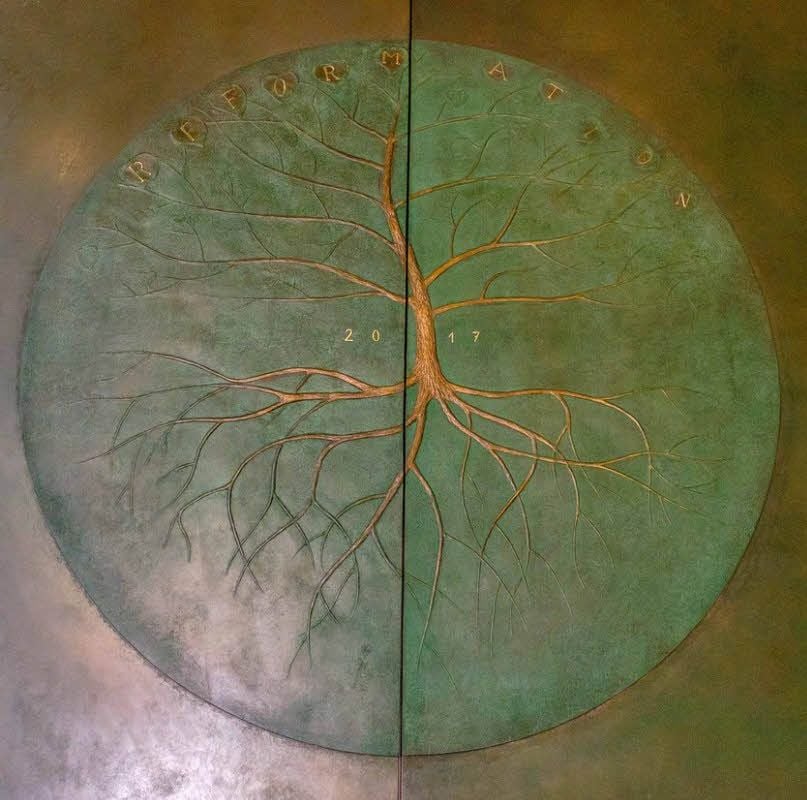 Kunstwerk und Brandschutztür in einem mit dem Lebensbaum der „Reformation 2017“ auf der einen Seite.