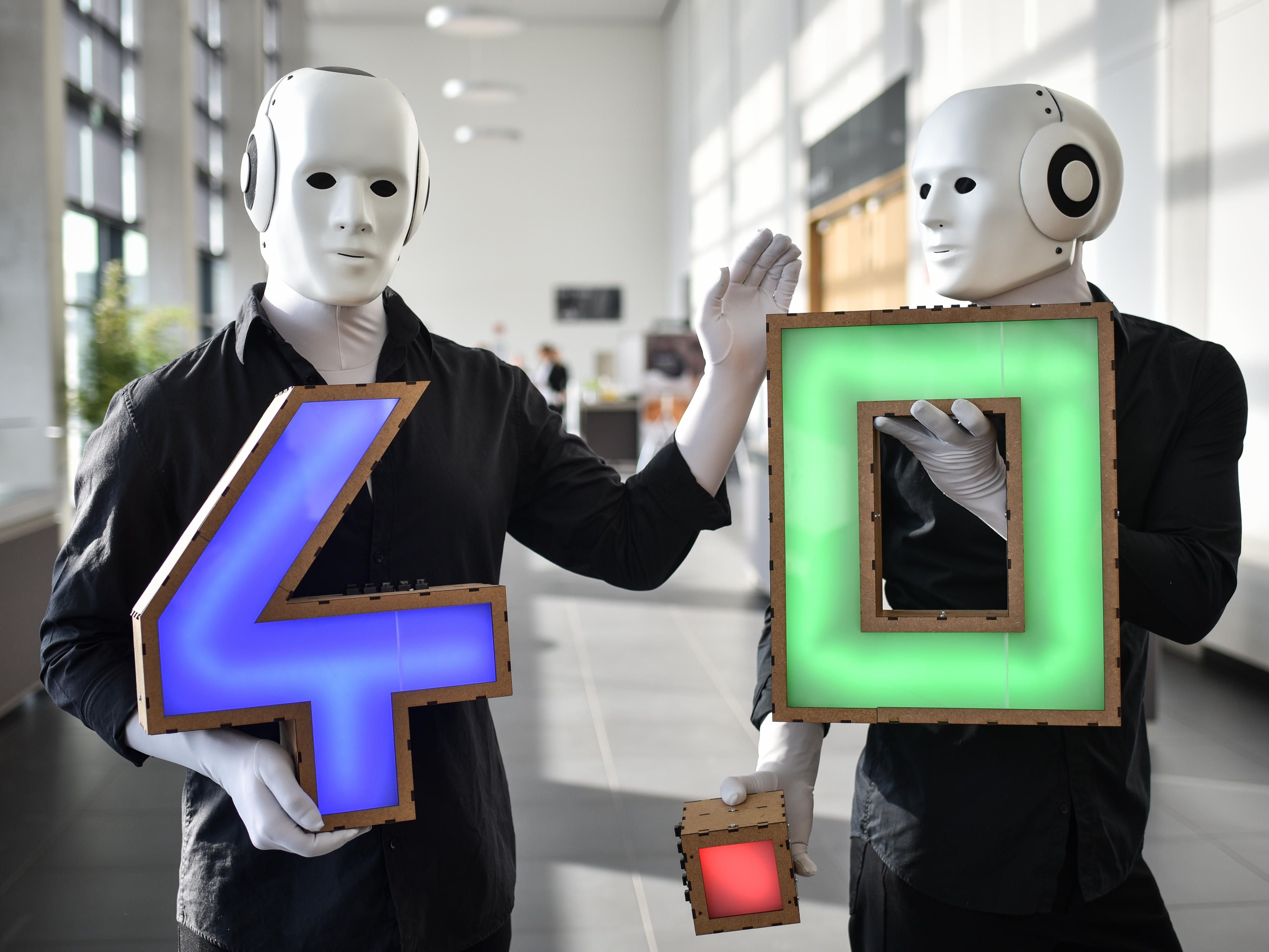 Zwei als Roboter verkleidete Darsteller bei der Hannover Messe beim Leaders Dialogue "Industrie 4.0 in Made in Germany".