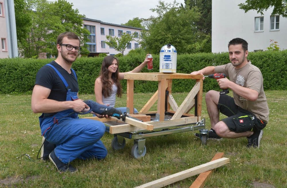 Auf der Wiese hinter dem Mensa-Keller werkeln (von links) an ihrem Gefährt für das Seifenkistenrennen. Wie es sich für Studenten der Hochschule Anhalt gehört, statten sie den X-Wing mit Hochtechnologie aus.