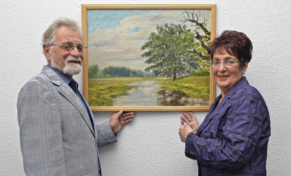 Wolfgang Gräfe und Helga Jovy präsentieren ein Landschaftsbild ihres Vaters. Dem ist in Dessau eine neue Ausstellung gewidmet.