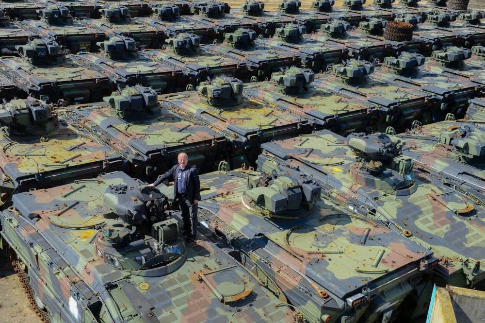 Firmenchef Peter Koch steht auf dem Dach eines Schützenpanzers.