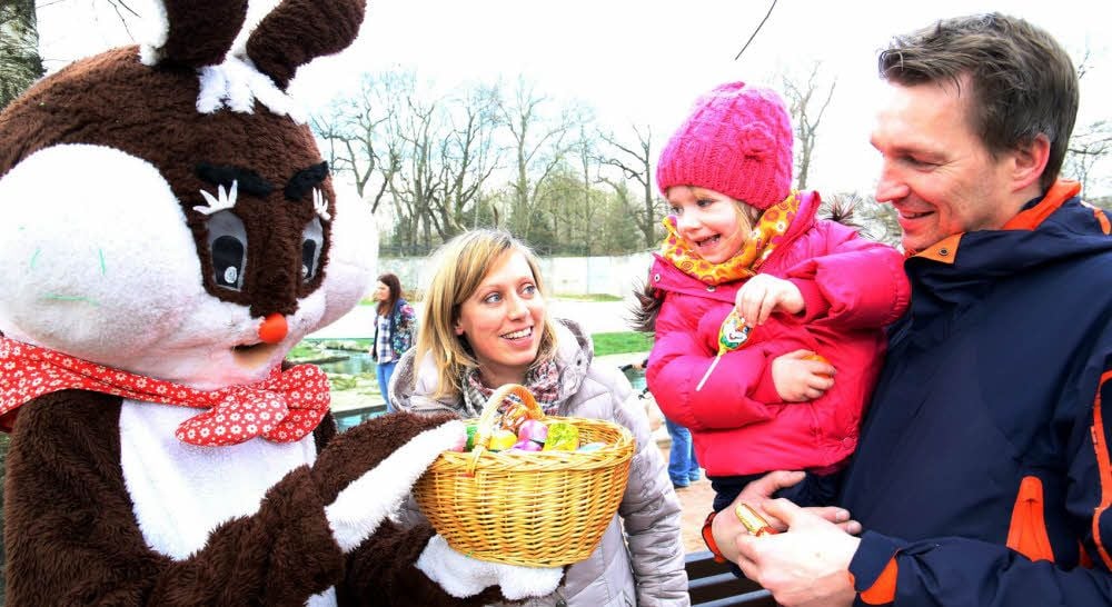 Der 14-jährige Caspar Unger (links) verteilte erstmals als Osterhase hunderte bunte Eier an die Kinder, hier auch an die dreijährige Tochter Katharina von Sandra und Marek Schulze aus Bernburg.
