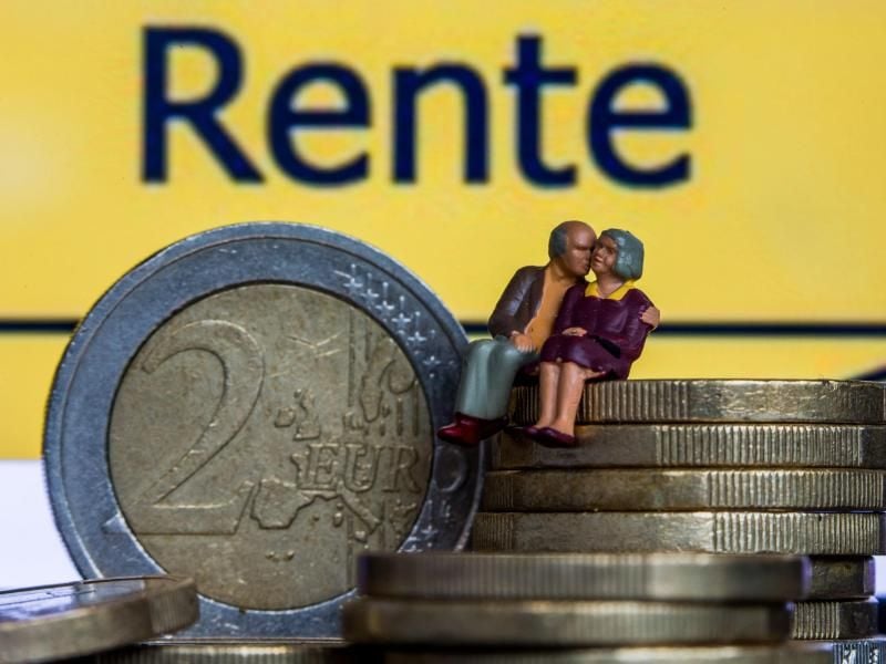 Modellfiguren eines Seniorenpaares sitzen auf Euro-Geldmünzen. Foto: Jens Büttner/dpa/Archiv