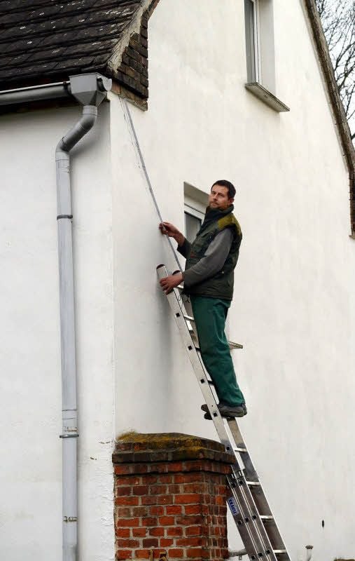 Hartmut Wolf zeigt einen 1,40 Meter langen Riss an der Hausfassade. Im Hof hat sich das Pflaster stellenweise abgesenkt.