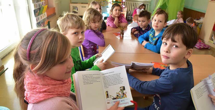Lea, Joel und Neo (v. l.) lesen vor und zeigen dazu die Bilder.