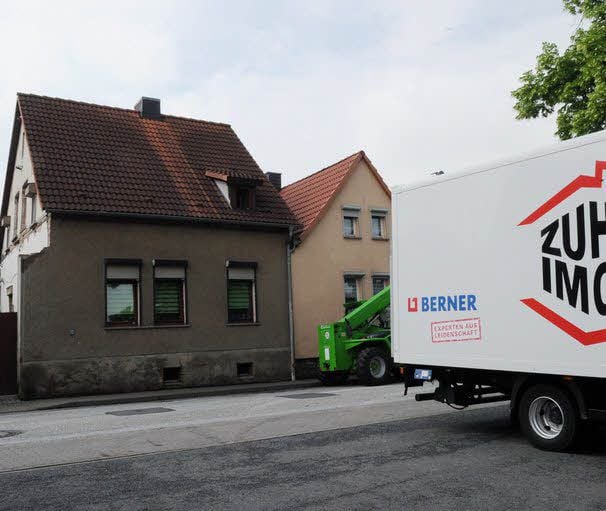 Vor dem Haus fahren die Lkw vor.