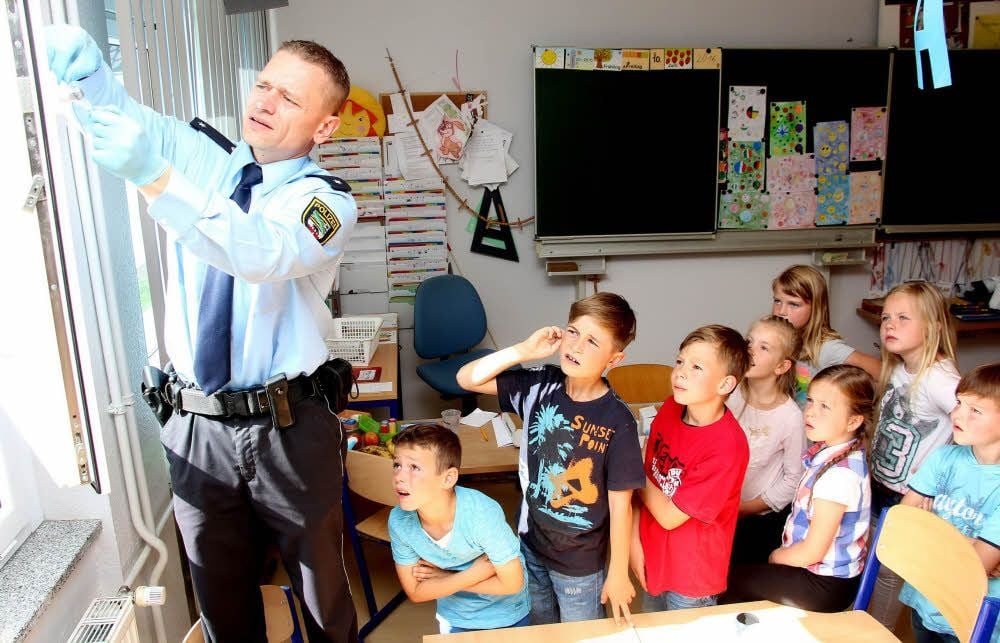 Christian Maertens zeigt den Kindern, wie Spuren gesichert werden.