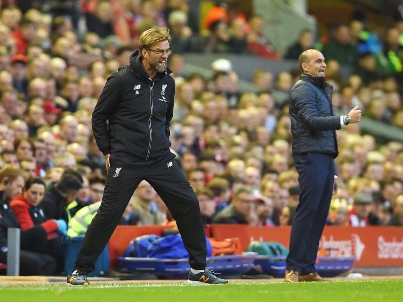 Liverpools Trainer Jürgen Klopp (l) schreit sein Team zum Sieg gegen den FC Everton von Coach Roberto Martinez (r). Foto: Peter Powell