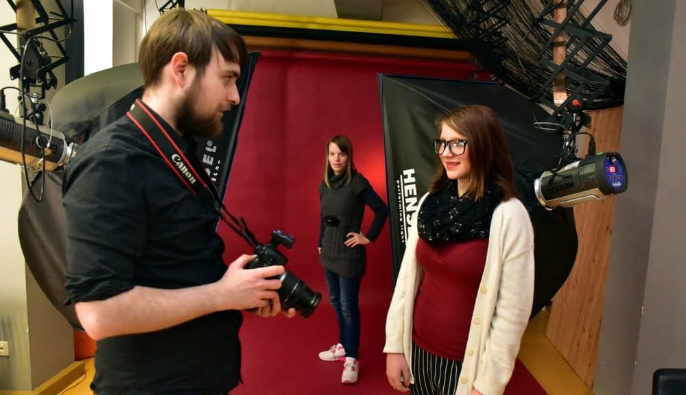 Paul Chemnitz erklärt Sophie (r.) die Kamera. Cora steht für die Aufnahmen Modell.