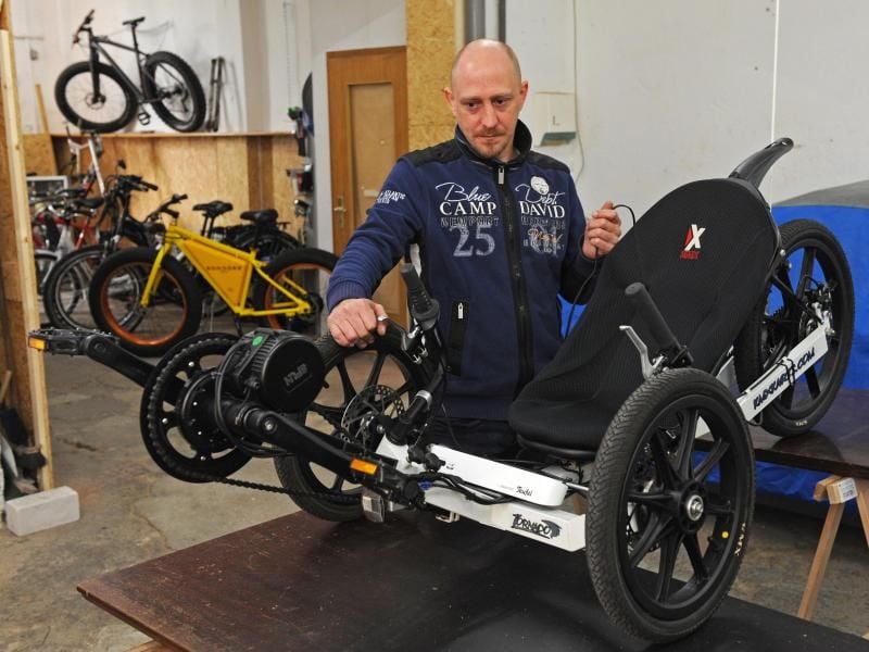 Christian Kelemen steht in seiner Fahrrad-Werkstatt im Fischereihafen von Bremerhaven (Bremen) neben einem Liegedreirad, das zur Zeit mit einem Elektroantrieb versehen wird. Der leidenschaftliche Entwickler und Tüftler baut in seiner Freizeit Fahräder zu E-Bikes um. Foto: Ingo Wagner
