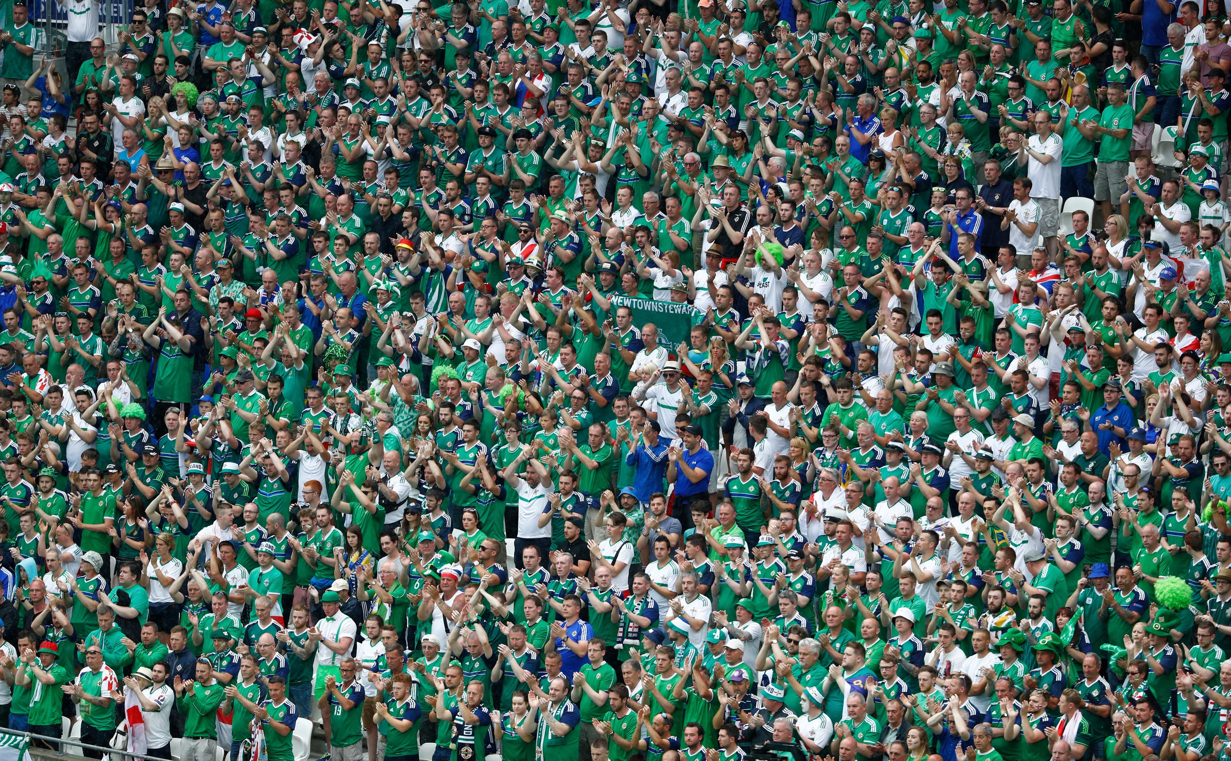 Die nordirischen Fans erheben sich und klatschen 60 Sekunden lang für den am Montag verstorbenen Darren Rodgers.