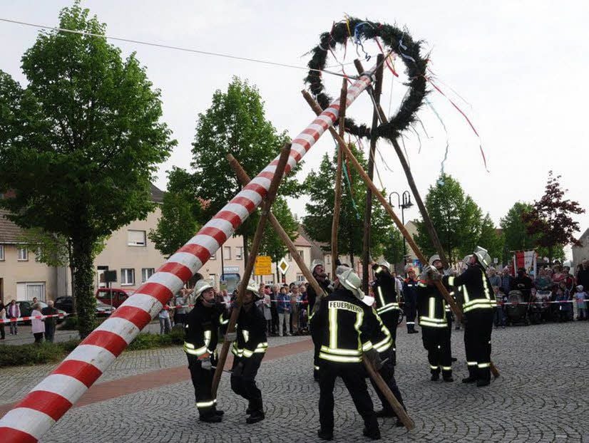 Die Feuerwehr setzt einen Maibaum.