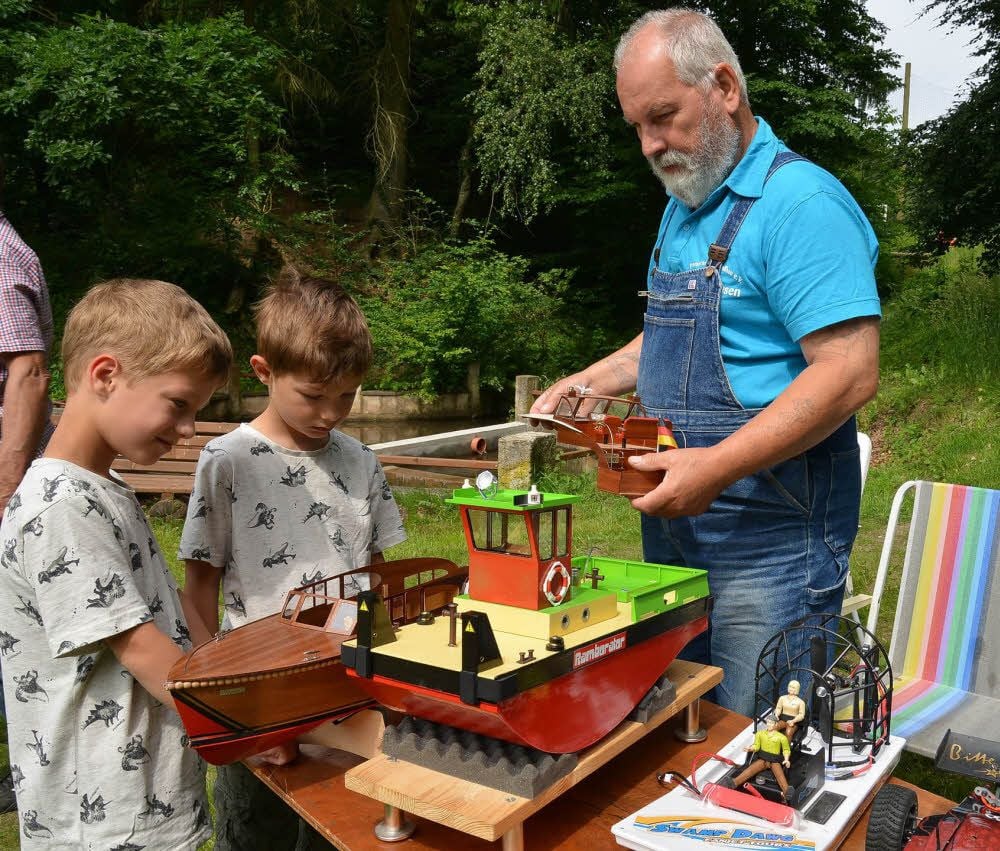 Rolf Thiele lässt die Zwillinge Vincent und Constantin Meyer unter das Deck der von ihm gebauten Reiseyacht schauen.