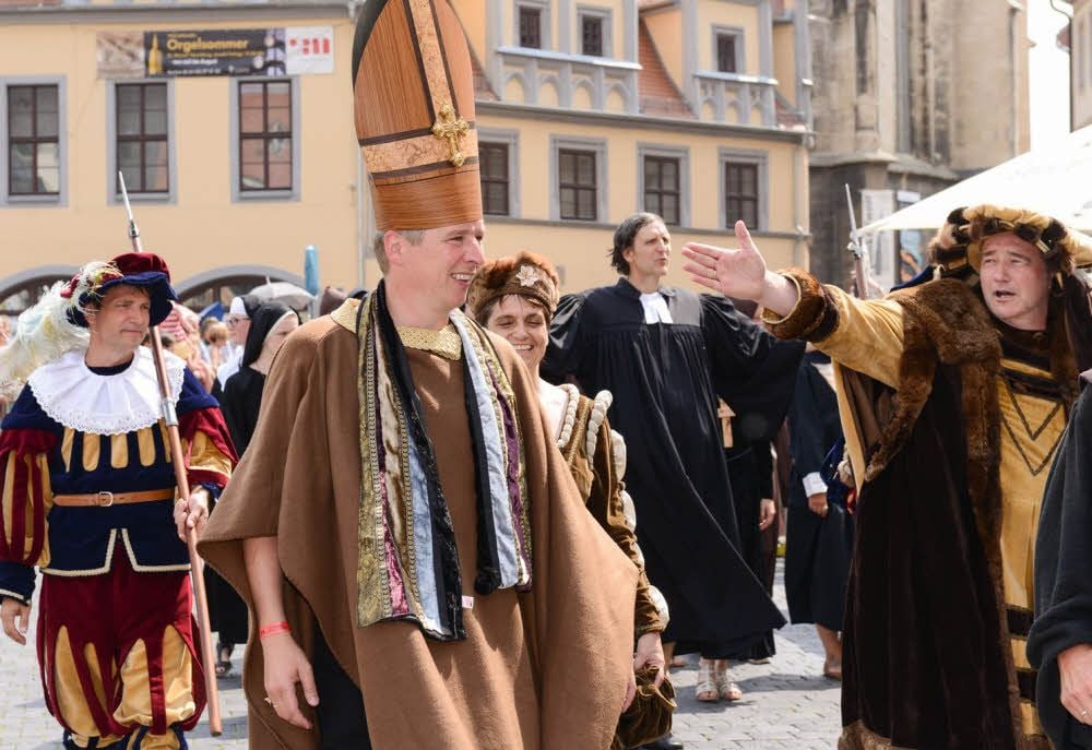 „Seht, das ist er“: Dirk Schmutzler (r.) preist den ersten lutherischen Bischof Deutschlands, Nikolaus von Amsdorf. Würdevoll schreitet Matthias Tränkner daher. 1552 war Amsdorf von Martin Luther in Naumburg in Amt und Würden gebracht worden. Mit diesem Bild, das erstmals im historischen Festumzug zu sehen war, wird an dieses besondere Ereignis der Reformation erinnert. Insgesamt umfasste der Zug 29 Bilder, die von 1321 Mitwirkenden gestaltet wurden. Verantwortlich dafür zeichneten die Stadtverwaltung, der Kirschfestverein sowie weitere Interessenten und Freunde des Kirschfests.