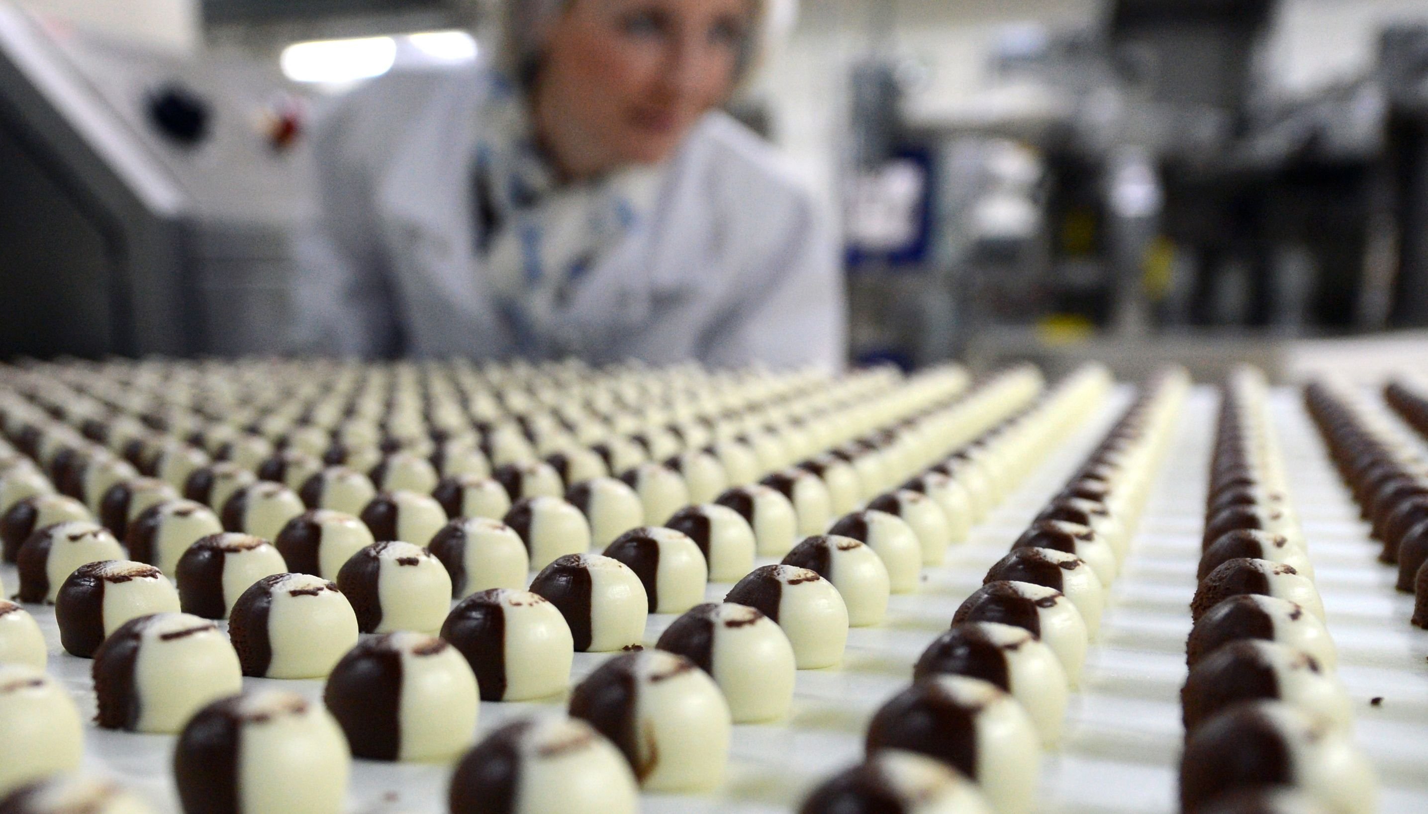 Eine Mitarbeiterin der Halloren Schokoladenfabrik AG überwacht in Halle die Produktion der Halloren-Kugeln.