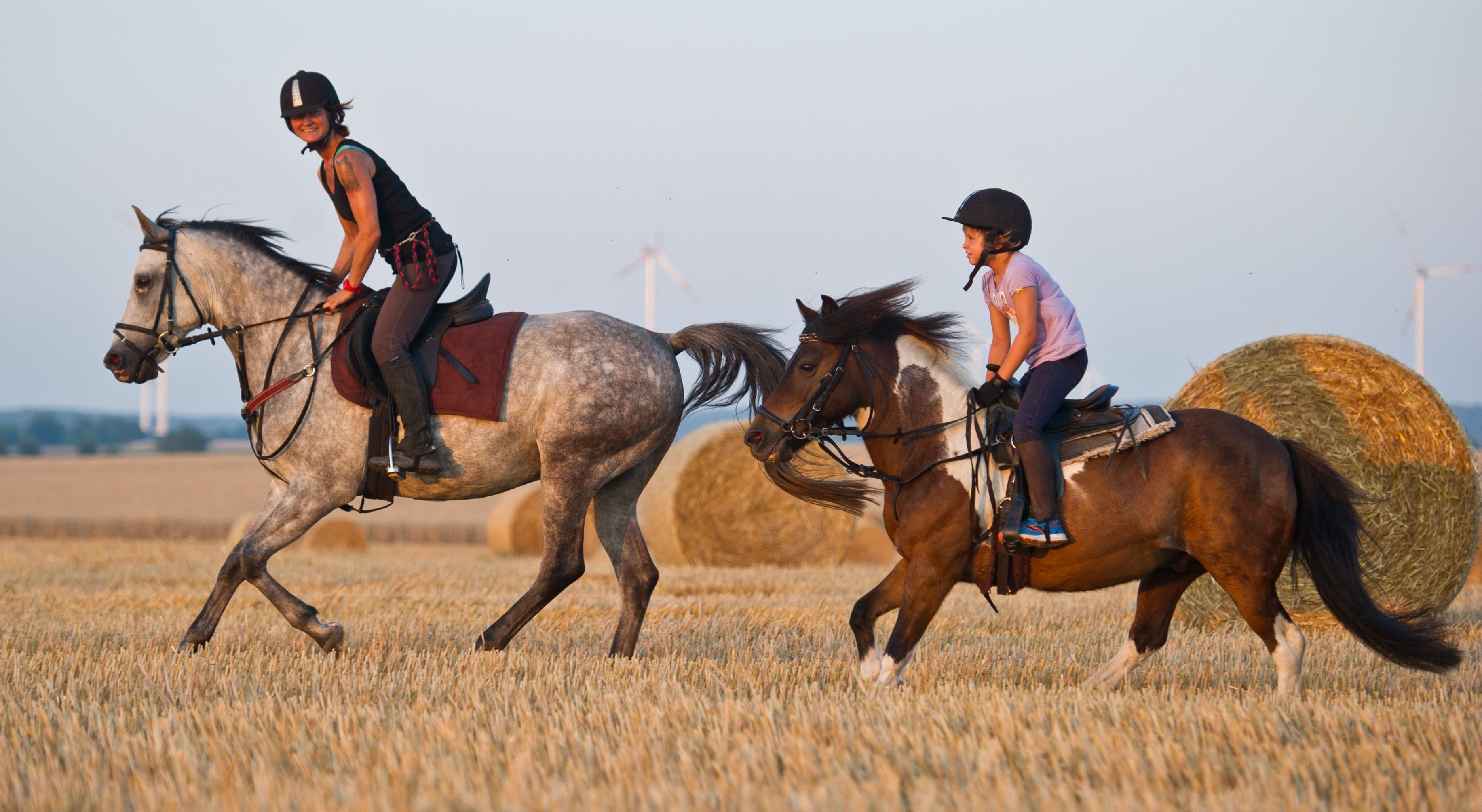 Eine Frau und ein Kind beim Reiten.