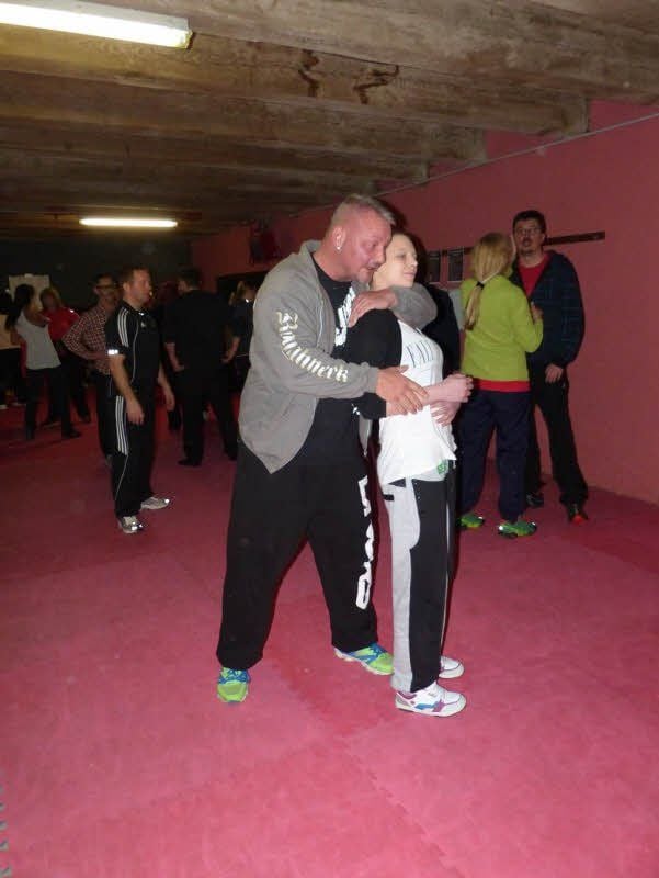 Norman Jendrejczyk zeigt einer jungen Frau, wie sie sich aus einer Umklammerung lösen kann.