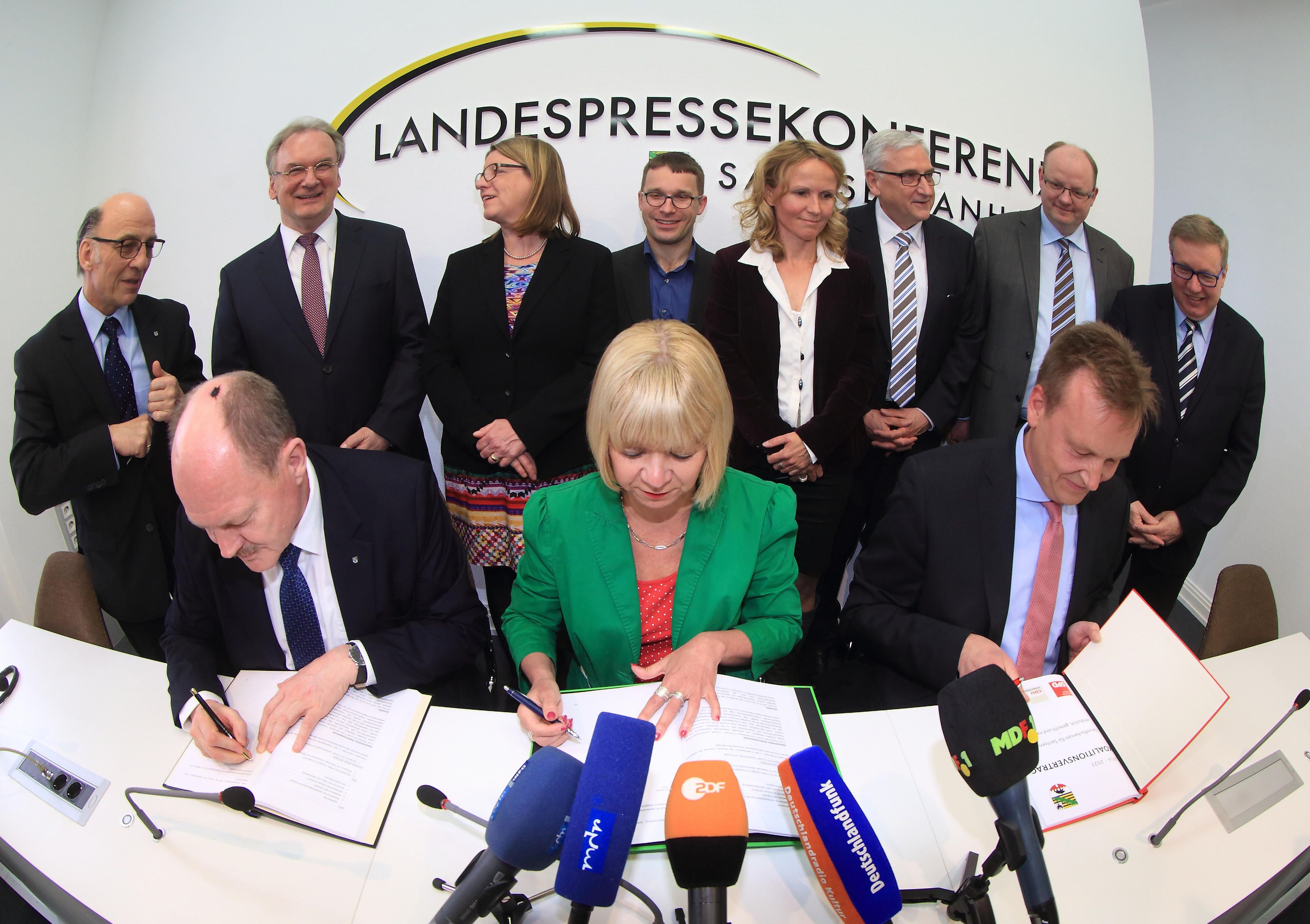 Historisches Dokument: Der erste schwarz-rot-grüne Koalitionsvertrag Deutschlands mit den Unterschriften der Parteichefs von CDU, SPD und Grünen ist perfekt.  CDU-Landeschef Thomas Webel, Grünen-Chefin Cornelia Lüddemann und SPD-Landesvorsitzender Burkhard Lischka (von links) unterzeichnen das Dokument.