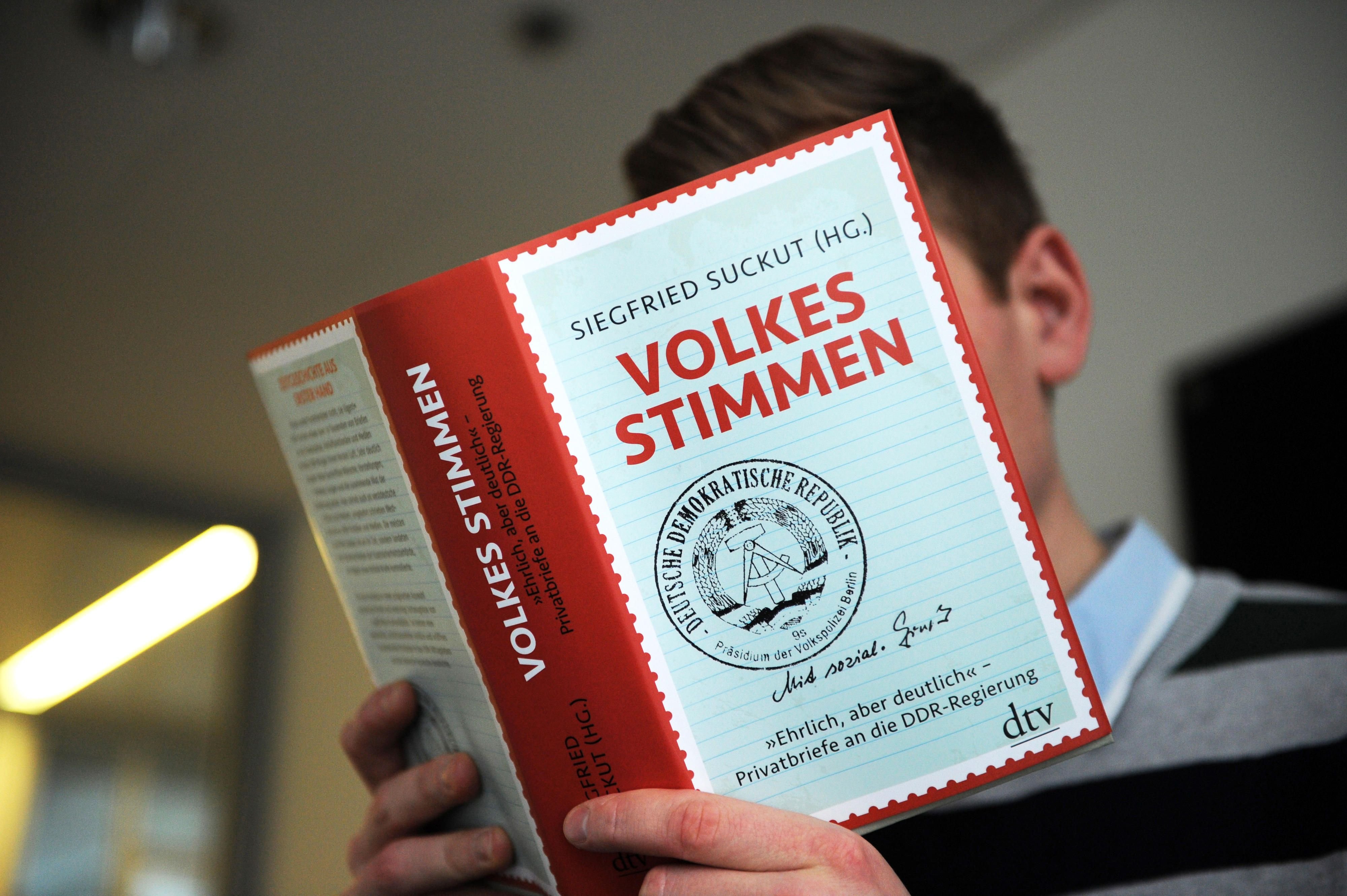 Ein Mann liest in Berlin das Buch «Volkes Stimmen».