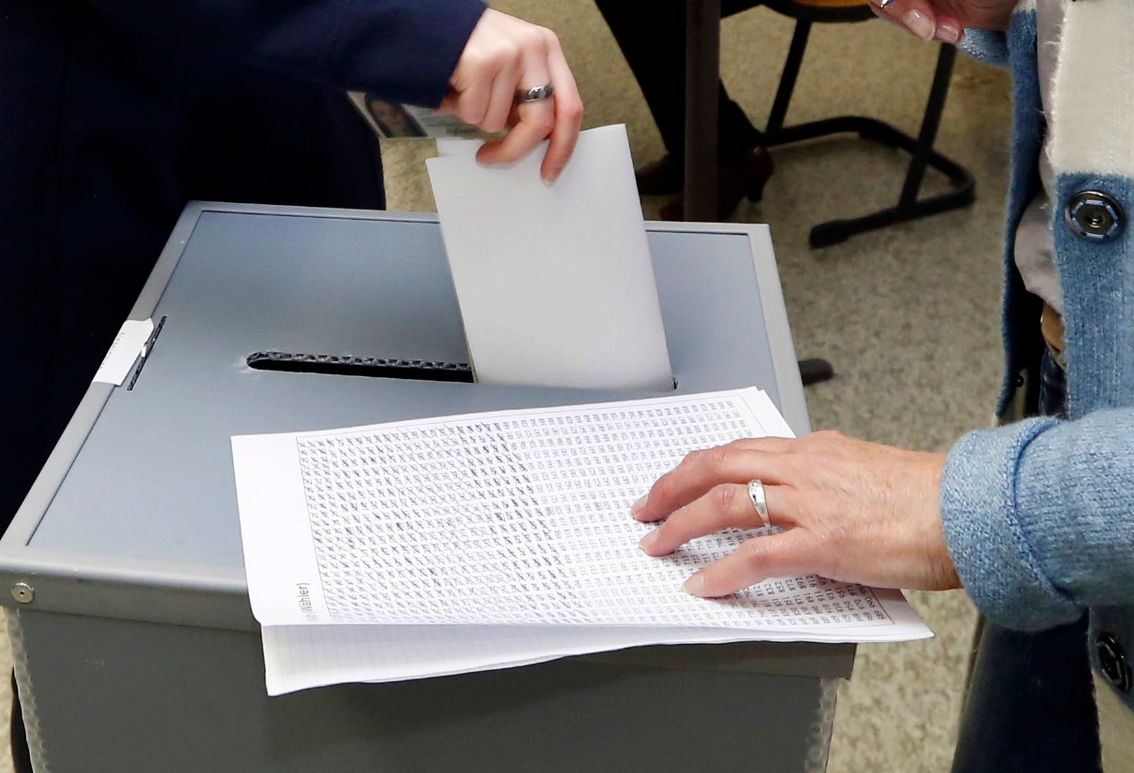 Ein Wahlzettel landet in der Wahlurne.