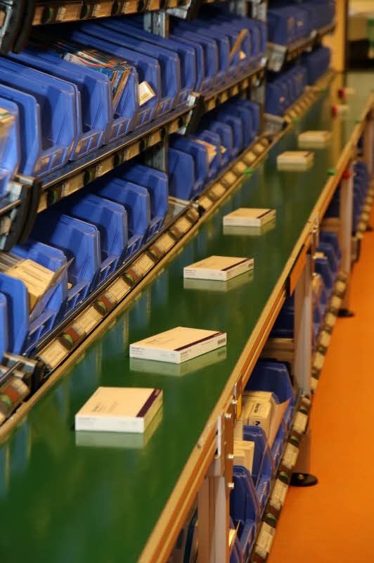Die Medikamente werden von den Apothekerinnen auf das Band gelegt. Die Zuordnung erfolgt automatisch.