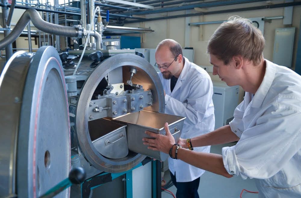 In Halle 63 der Hochschule Anhalt in Köthen bestücken die wissenschaftlichen Mitarbeiter Tobias Fritsche und Reik Feistauer einen Vakuumwalzen-Trockner. In diesem Gerät kann aus Milch, Milchpulver hergestellt werden.