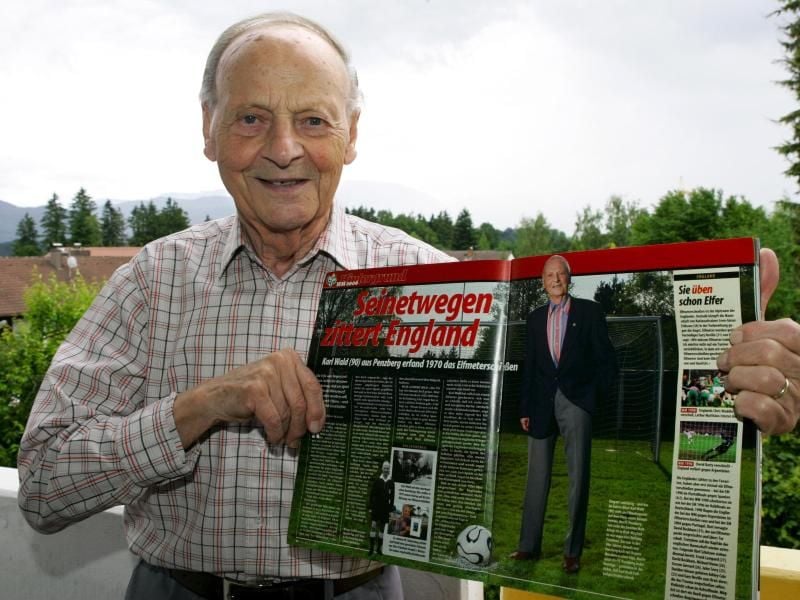 Karl Wald, der Erfinder des Elfmeterschießens, posiert 2006 im bayerischen Penzberg mit einem Zeitungsartikel über ihn. Foto: Matthias Schrader