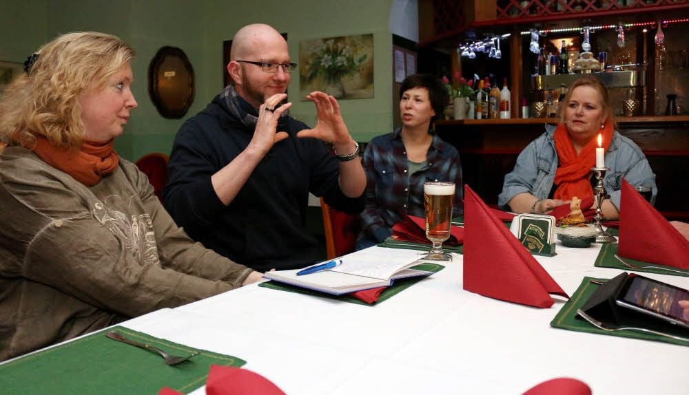 Im Gespräch bringt Henry Niekrawietz den Teilnehmern des Stammtischs einige Gebärden bei. Seine Ehefrau (3.v.l.) hilft bei Verständigungsproblemen. Sandra Niekrawietz ist nicht gehörlos. Sie beherrscht die Gebärdensprache dennoch perfekt.