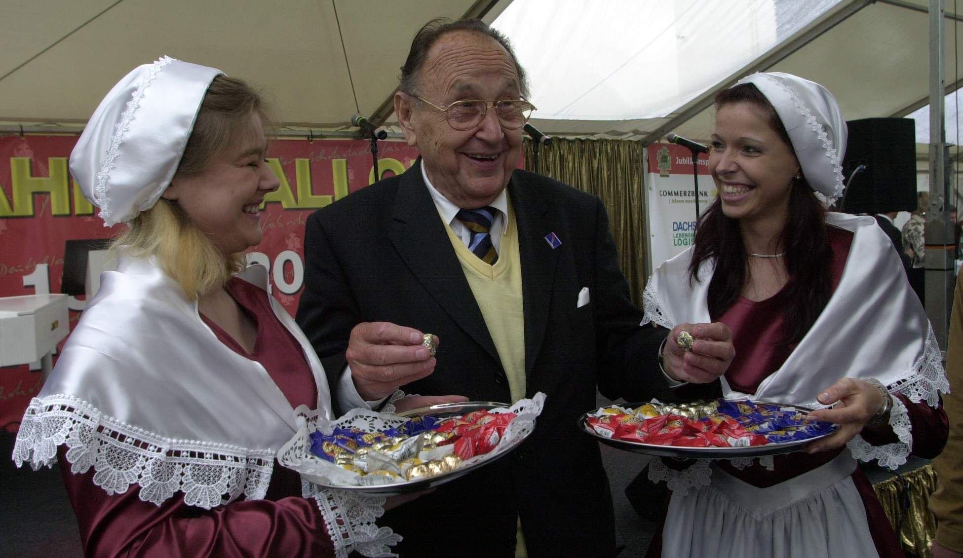 Hans-Dietrich Genscher, als Liebhaber von Süßigkeiten bekannt, greift sich gleich 2 der Hallorenkugeln von den beiden Schokoladenmädchen Olivia Husung (li) und Heike Feitsch (re).