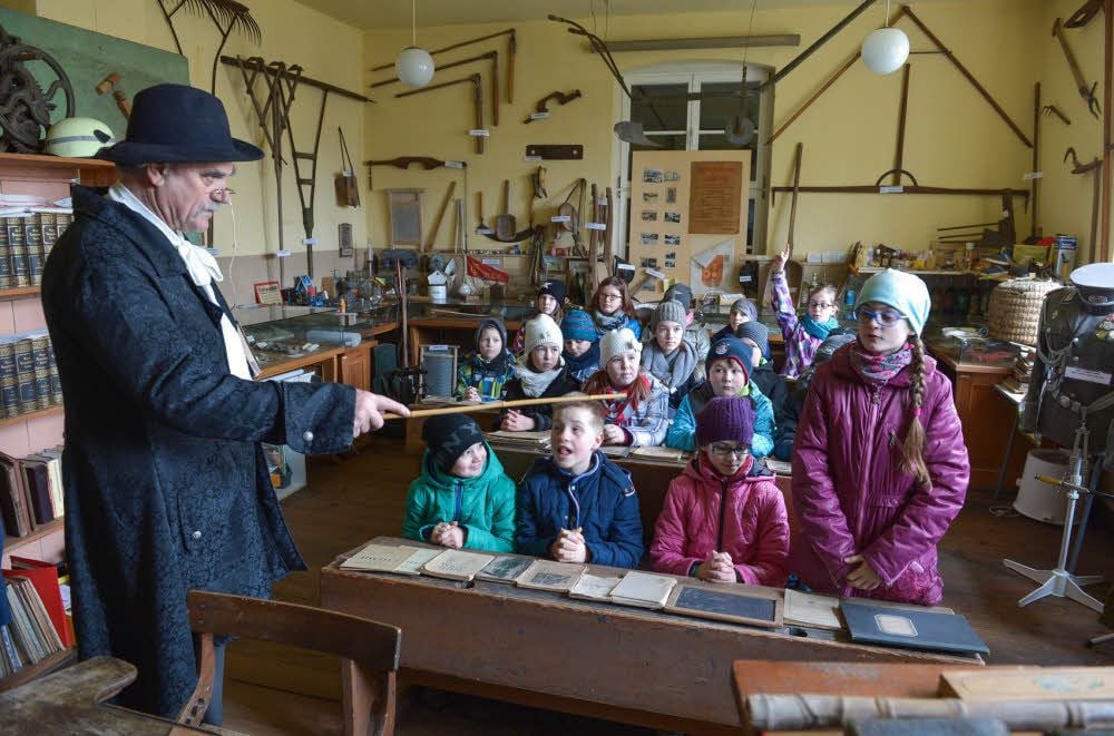 Für die vierte Klasse der Grundschule Görzig ist Axel Finsch im Museum in die Rolle eines Dorfschullehrers vor 150 Jahren geschlüpft. Er erklärt den Kindern, wie der Unterricht damals ablief.