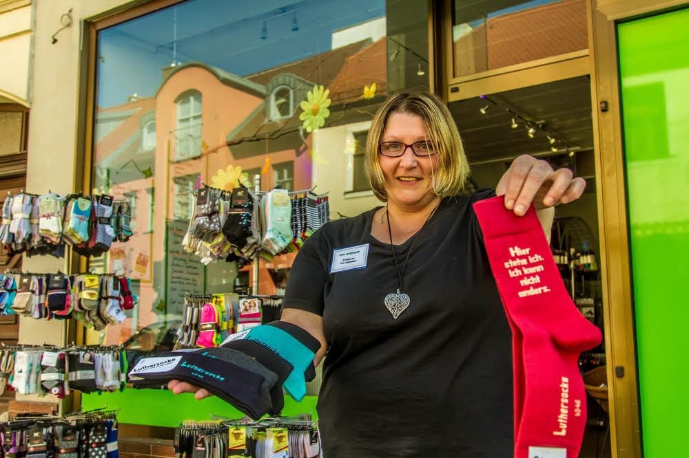 Reformation an den Füßen. Ina Langhammer präsentiert die Luthersocke(n), ein seit mehr als 20 Jahren beliebtes Mitbringsel aus der Lutherstadt. Geht’s nach Langhammer, gibt es bald ein neues Modell.