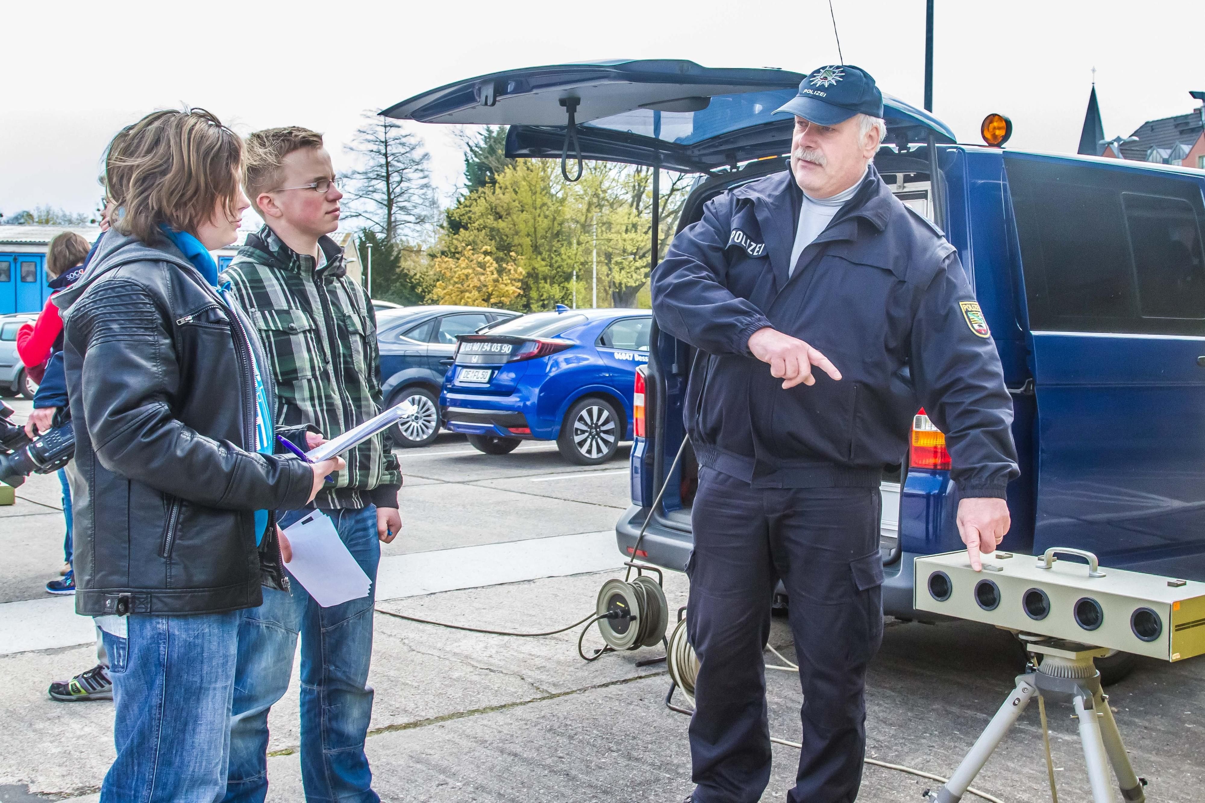 Elias und Adrian lassen sich von Frank Blohm einen Blitzer erklären.