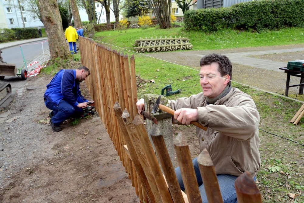 Daniel Krauß (links) und Lehrer Frank Bräuner setzen den neuen Zaun, den Schüler im Unterricht gebaut haben.