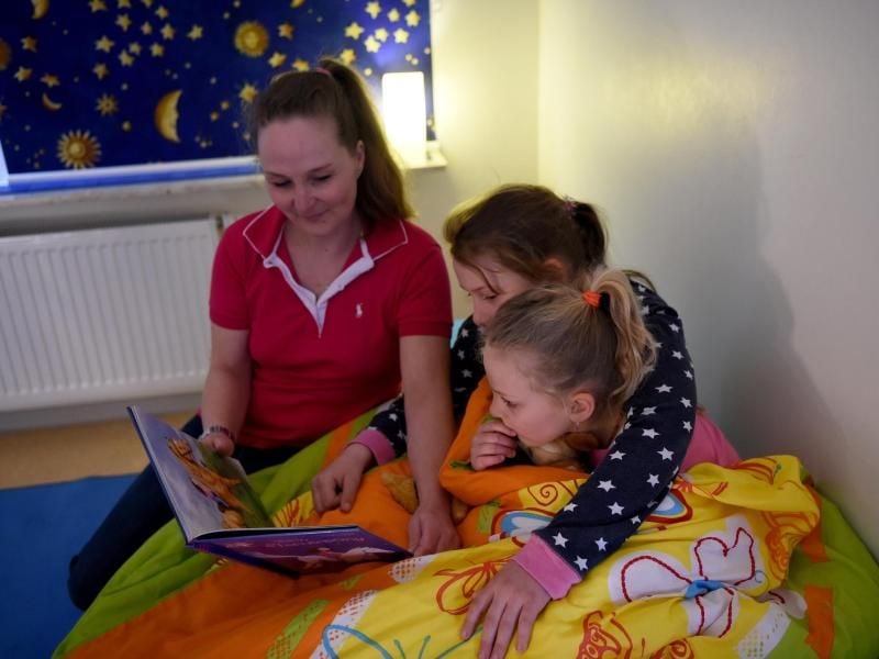 Skady-Lee(10) und Lucy-Mae(6) sitzen auf einem Bett neben ihrer Mutter W.Rüdig. Foto: Carsten Rehder