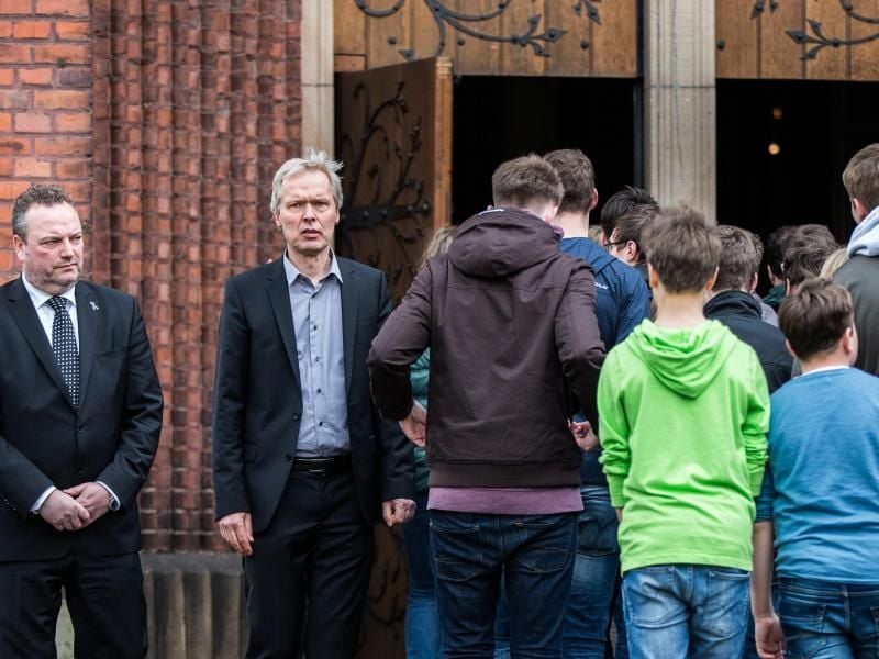 Der Bürgermeister der Stadt, Bodo Klimpel (l), und der Schulleiter, Ulrich Wessel, warten am Eingang der St. Sixtus Kirche. Schüler des Joseph-König-Gymnasiums gedenken der Opfer des Germanwings-Absturzes. Foto: Marcel Kusch